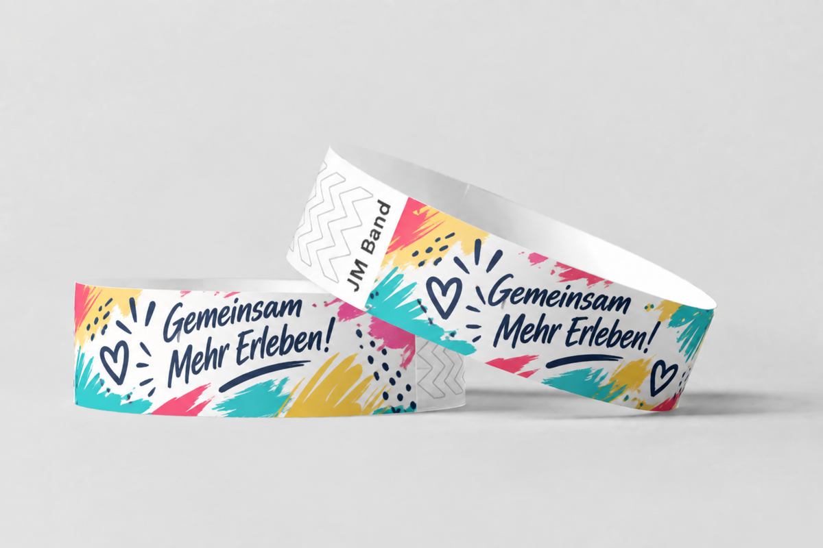 Two paper wristbands with colourful hand-lettered print