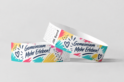 Two paper wristbands with colourful hand-lettered print